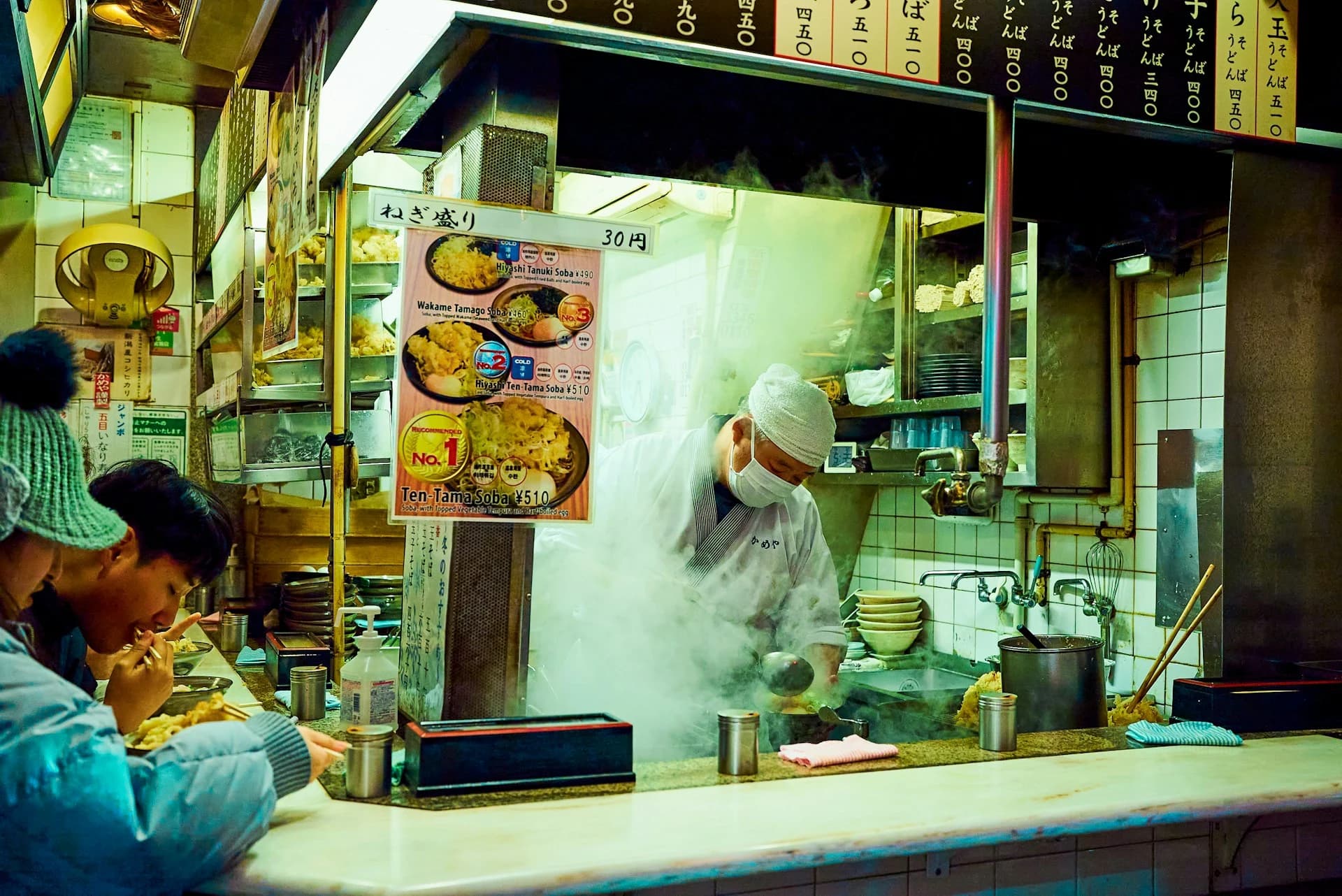 Narrow Golden Gai alley in Shinjuku lined with tiny lit bar fronts at night