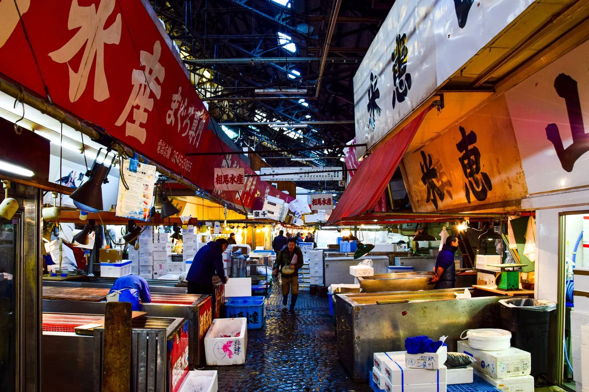 Vendor slicing fresh tuna at a busy Tsukiji outer market stall in Tokyo